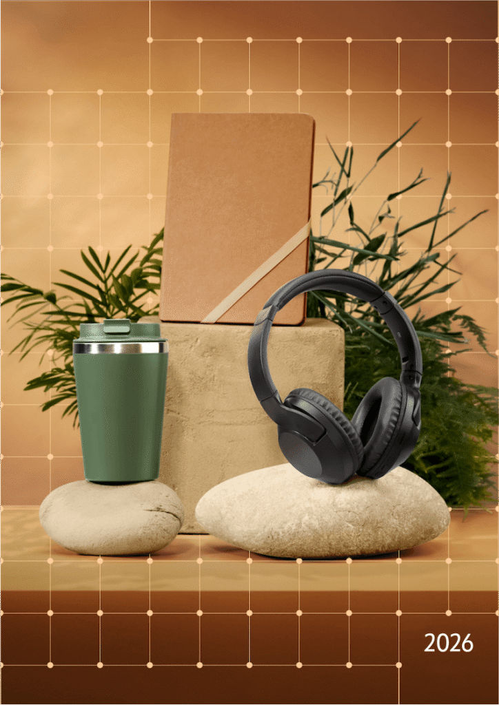 Green insulated tumbler with a lid sits on a smooth stone, beside a cardboard box on stacked rocks, while black over-ear headphones rest nearby; warm plant backdrop with a grid pattern and '2026' in the corner.